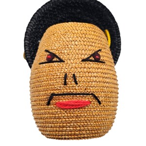 Close up of wool embroidered face on vintage straw handbag