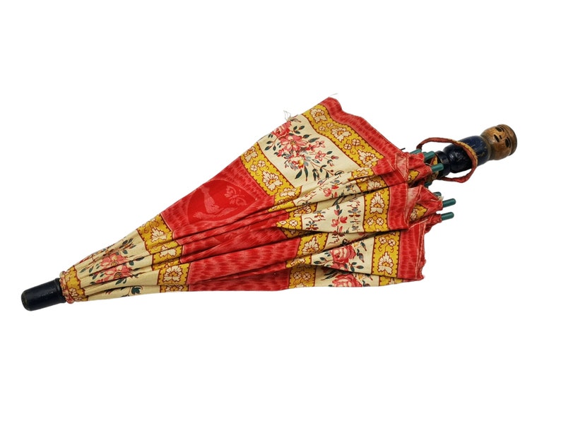 Antique French child's parasol in cretonne fabric with a design of floral garlands and cherubs in oval medallions, in tones of coral, pink, beige, honey and sage green, wooden handle with hand painted face.