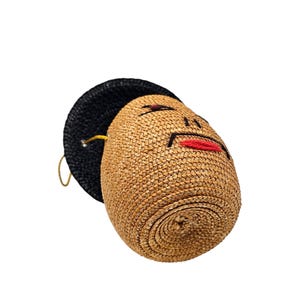 Bottom view of figural straw handbag with yellow cord strap