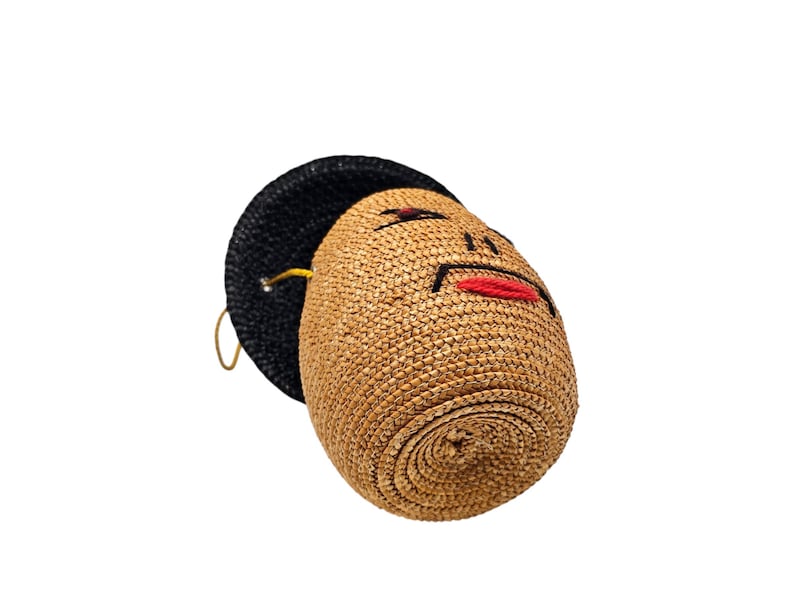 Bottom view of figural straw handbag with yellow cord strap