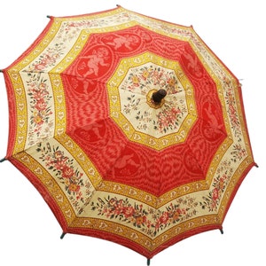 Antique French child's parasol in cretonne fabric with a design of floral garlands and cherubs in oval medallions, in tones of coral, pink, beige, honey and sage green, wooden handle with hand painted face.