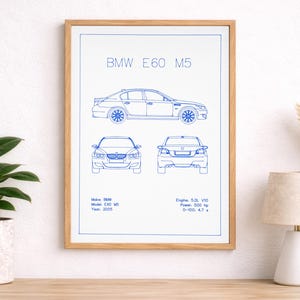 May include: A framed print featuring a blue line drawing of a BMW E60 M5 car. The print includes side, front, and rear views, along with specifications: 5.0L V10 engine, 500 hp, and 0-100 in 4.7 seconds. The year is 2005.