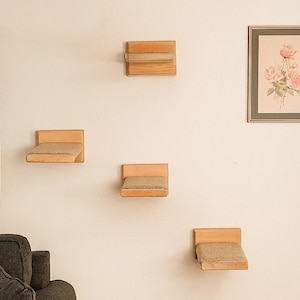 May include: A wall-mounted cat furniture set with four wooden platforms and a framed floral print. The platforms have a natural wood finish and beige cushions. The artwork features pink roses.