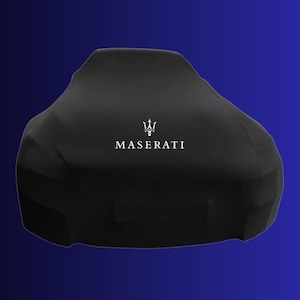 Puede incluir: Una funda negra para coche con el logotipo de Maserati en blanco. La funda cubre un coche, ocultando su forma. El fondo es un degradado de azul oscuro a azul claro.