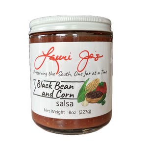 Pode incluir: Um frasco de salsa de feijão preto e milho Lauri Jo's. O rótulo apresenta o texto "Preserving the South, One Jar at a Time". O frasco contém uma salsa com feijão preto e milho visíveis. Peso líquido 227g.