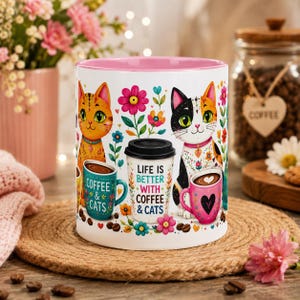 Könnte beinhalten: Weißer Keramik-Kaffeebecher mit rosa Innenraum, mit farbenfrohen Illustrationen von Katzen, Blumen und Kaffeetassen. Der Becher trägt den Text "LIFE IS BETTER WITH COFFEE & CATS" und "COFFEE & CATS".