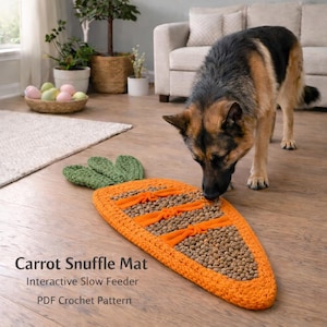 Könnte beinhalten: Ein orangefarbener, karottenförmiger Schnüffelteppich mit grünen Blättern, der als interaktiver langsamer Futterautomat für Hunde konzipiert wurde. Der Teppich ist mit Hundefutter gefüllt und hat orangefarbene Stoffstreifen. Ein Deutscher Schäferhund schnuppert an dem Teppich.