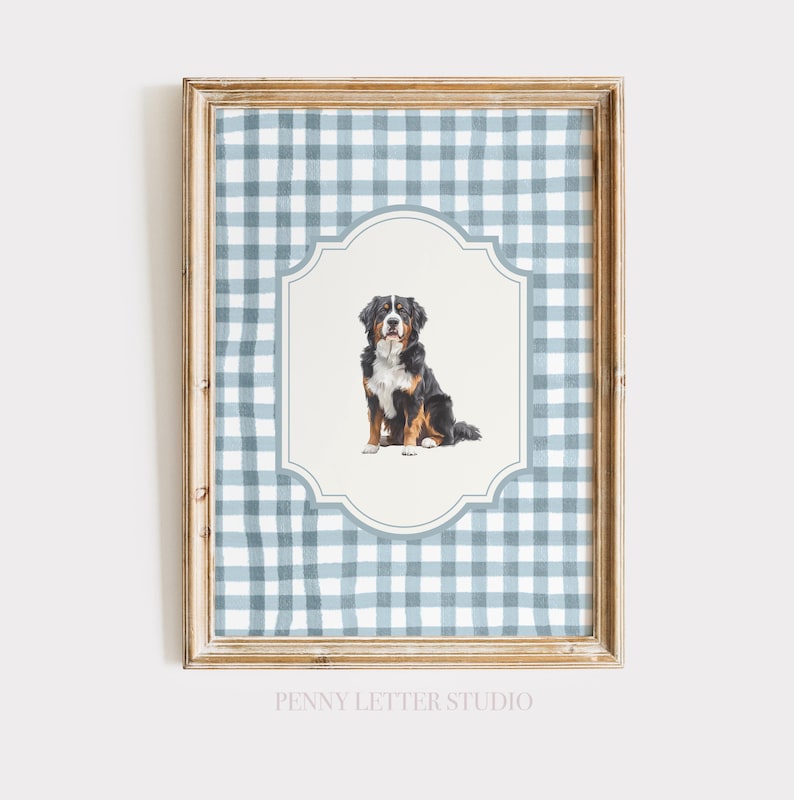 A framed print featuring a Bernese mountain dog sitting in the center, surrounded by a blue and white gingham pattern.