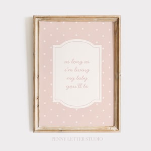 A framed print with a pink background and white polka dots, featuring a message that reads "as long as I'm living my baby you'll be".