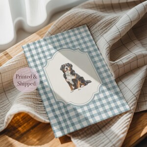 A printed and shipped card featuring a picture of a dog sitting on a wooden surface, with a checkered pattern and a pink circle indicating it is a printed and shipped item.
