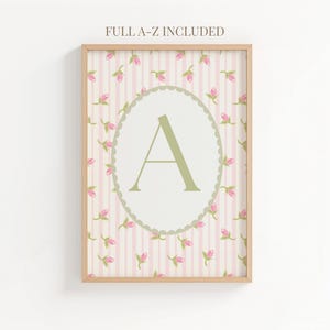 Puede incluir: Un estampado enmarcado con la letra "A" en verde claro, dentro de un óvalo blanco con borde festoneado. El fondo presenta rayas rosas y pequeños motivos florales rosas. El texto "FULL A-Z INCLUDED" se muestra en la parte superior.