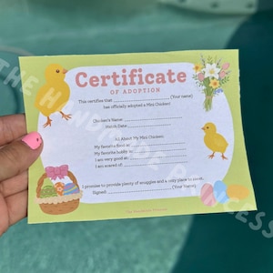 May include: A certificate of adoption with the text "Certificate of Adoption" and space for the adopter's name. The certificate features illustrations of a yellow chick, a basket of Easter eggs, and flowers.