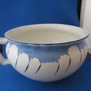 Pode incluir: Bacia de cerâmica branca e azul com uma pega. A bacia apresenta uma borda azul e um padrão de formas brancas em forma de nuvem com detalhes azuis. O interior é branco.