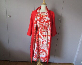 May include: A vintage red coat and dress set. The coat is a solid red, long-sleeved design. The dress underneath features a white, red, and tan floral pattern. The outfit is displayed on a mannequin.