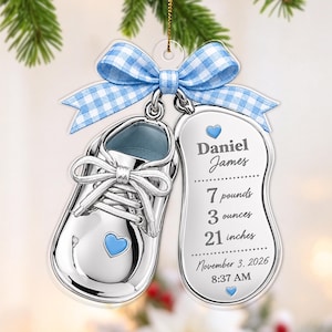 Puede incluir: Un adorno de zapato de bebé plateado con un lazo de cuadros azul, que incluye una etiqueta grabada con el nombre Daniel James, datos de nacimiento 7 pounds 3 ounces, 21 inches, 3 de noviembre de 2026 y 8:37 AM, con pequeños corazones azules.