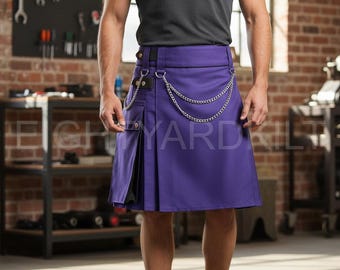 Könnte beinhalten: Ein lila Kilt mit Kettenverzierung. Der Kilt hat ein plissiertes Design und eine Seitentasche. Er wird mit einem schwarzen Gürtel und einem schwarzen T-Shirt getragen. Der Hintergrund zeigt eine Werkstatt mit Werkzeugen und Backsteinmauern.