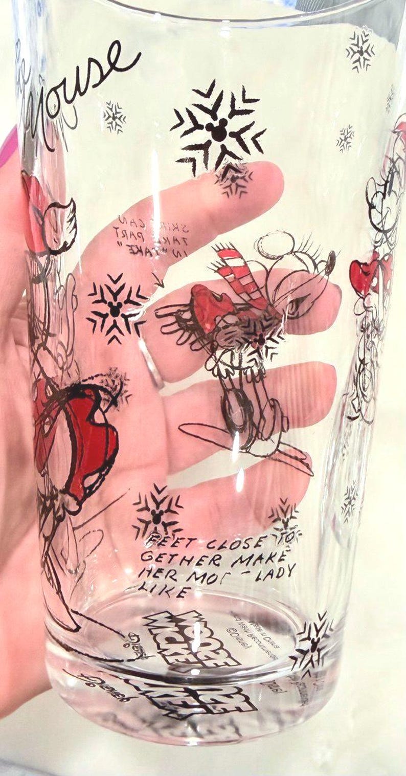 Pu&ograve; includere: Bicchiere trasparente con un disegno a mano di un personaggio di topo con cappello e sciarpa rossi, e fiocchi di neve. Il bicchiere ha la parola "Mouse" e il testo "Feet close to gether make her mot-lady like".