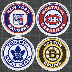 May include: Four circular stickers featuring NHL team logos. The New York Rangers logo is in blue, red, and white. The Montreal Canadiens logo is red, white, and blue. The Toronto Maple Leafs logo is blue and white. The Boston Bruins logo is black, yellow, and white.