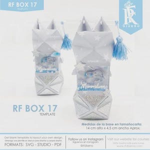 Peut inclure: Deux boîtes décoratives en papier avec un motif d'étoile et de couronne. Les boîtes sont gris clair avec un motif géométrique et présentent une petite figurine d'éléphant à l'intérieur. Dimensions de la base : 14 cm de haut x 4,5 cm de large.
