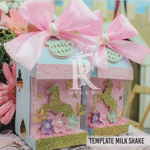 Pode incluir: Duas caixas decorativas em azul claro e rosa, com um design de unic&oacute;rnio. Cada caixa tem um grande la&ccedil;o rosa e uma p&eacute;rola. As caixas t&ecirc;m uma base dourada brilhante e o texto "TEMPLATE MILK SHAKE".