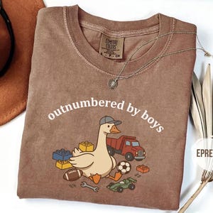 Espresso shirt with playful “outnumbered by boys” goose graphic