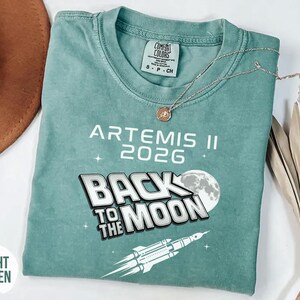 Light Green Comfort Colors Artemis II shirt with white retro space exploration design