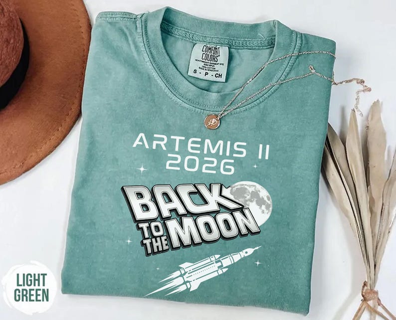 Light Green Comfort Colors Artemis II shirt with white retro space exploration design