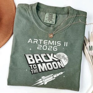 Moss Comfort Colors Back To The Moon NASA shirt with Artemis II rocket launch illustration