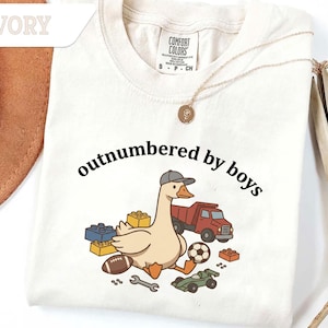 Ivory shirt with black text and cute goose surrounded by toys