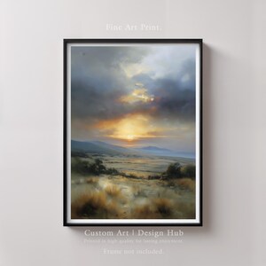 Puede incluir: Una impresión artística enmarcada de un paisaje con una puesta de sol sobre un campo y montañas. El cielo está lleno de nubes dramáticas y el sol es de color naranja brillante. Incluye el texto "Fine Art Print" y "Custom Art | Design Hub."