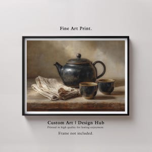 May include: A framed fine art print featuring a still life composition. The image showcases a dark, antique teapot, two matching cups, and a folded linen cloth. The artwork is set against a neutral background, creating a classic and elegant aesthetic.