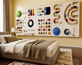 May include: A modern bedroom features a large, cream-colored headboard with colorful, geometric shapes and spheres. The bed has white linens, a green pillow, and a brown blanket. A patterned rug sits at the foot of the bed.