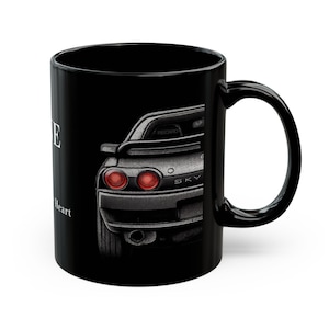 以下が含まれることがあります： 赤いテールライトが付いた車のリアエンドの詳細なイラストが描かれた黒いセラミックマグ。 「SKY」の文字が見えます。 マグカップには「Love in my Heart」の文字もプリントされています。