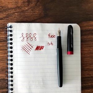 Penna stilografica unica in metallo nero e rosso con pennino in argento extra liscio per calligrafia, journaling, lettering e firme.