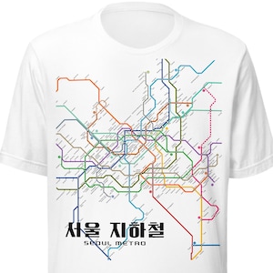 Może przedstawiać: Biała koszulka z kolorową mapą systemu metra w Seulu. Projekt mapy zawiera linie w różnych kolorach, z koreańskim tekstem i angielskim tekstem "Seoul Metro" wydrukowanym poniżej.