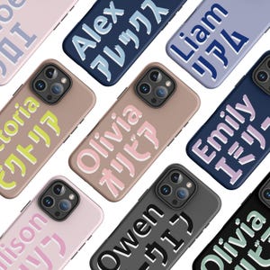 May include: A collection of personalized phone cases in various colors, including pink, tan, navy, and black. Each case features a name in English and Japanese, such as "Olivia" and "Alex". The cases have a sleek design with camera cutouts.