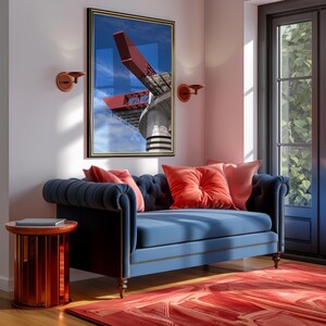Könnte beinhalten: Wohnzimmer mit blauem, getuftetem Sofa, korallenfarbenen Kissen und rotem Teppich. Ein gerahmter Architektur-Druck hängt über dem Sofa. Ein kleiner, roter Beistelltisch und Wandleuchten ergänzen die Einrichtung.