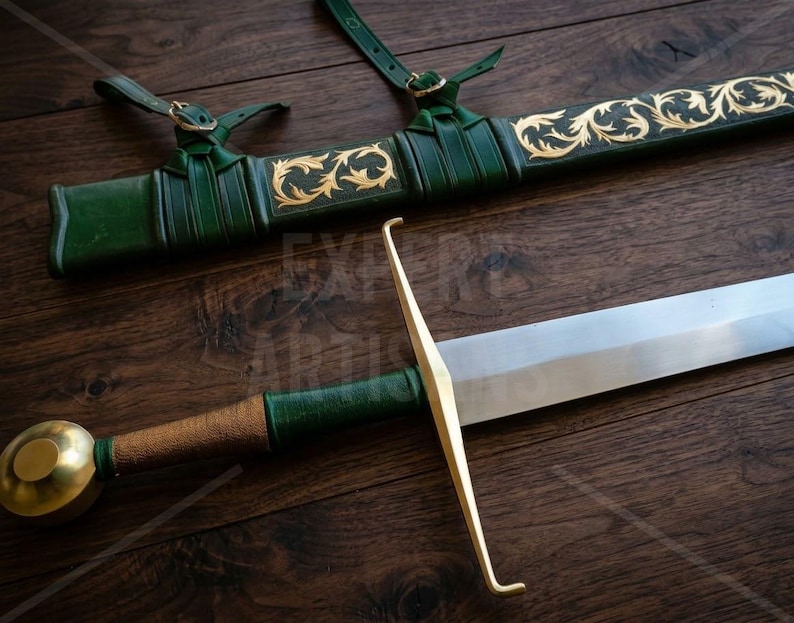 May include: A sword with a silver blade, a gold crossguard, and a green leather-wrapped handle with a gold pommel. Beside it lies a matching green leather scabbard featuring gold filigree scrollwork and two leather attachment straps.
