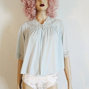 May include: A light blue sleep shirt with a lace trim and a button closure. The shirt has short sleeves and a gathered neckline.
