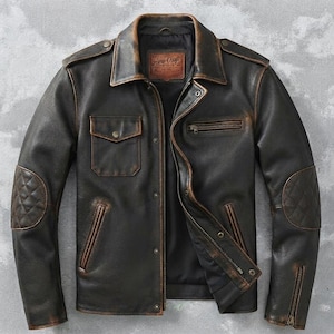 May include: A dark brown leather jacket with a distressed finish, featuring a pointed collar, a front zipper closure with snap buttons, a chest pocket with a flap, a zippered chest pocket, and quilted elbow patches on the sleeves with zippered cuffs.