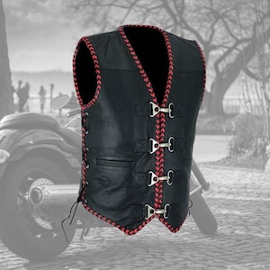 Może przedstawiać: Czarna skórzana kamizelka z czerwonymi plecionymi wykończeniami i srebrnymi sprzączkami. Kamizelka ma dekolt w serek i klasyczny styl motocyklowy. Posiada sznurowanie boczne i dwie przednie kieszenie. Stylowy element dla entuzjastów motocykli.