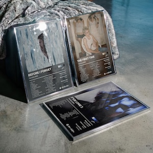 May include: Three rectangular framed posters featuring album artwork for The Kid LAROI. Each print displays a photographic image, tracklist, release date, album length, record label, and a Spotify code. The frames are silver-toned metal.