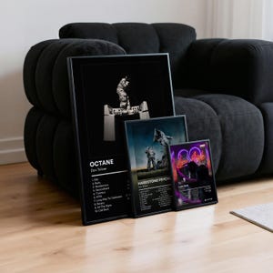 May include: Three framed art prints leaning against a black sofa. The largest print is black and white with the text "OCTANE Don Toliver". The other two prints feature images of people and text. The smallest print has a neon pink design and the text "Love Sick".