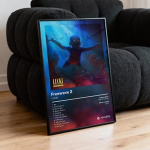 以下が含まれることがあります： LUCKIのアルバム「Freewave 2」のカバーアートをあしらった額装アートプリント。青と赤を基調とした水中にいる赤ちゃんのイラスト。アルバムタイトル、アーティスト名、トラックリスト、リリース情報が表示されています。