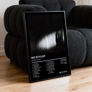 Peut inclure: Affiche encadrée noire et blanche de l'album "NO STYLIST" de Destroy Lonely. L'affiche présente une liste des titres, la date de sortie et la durée de l'album. L'image sur l'affiche est une photo en niveaux de gris d'une personne. Le cadre est noir.