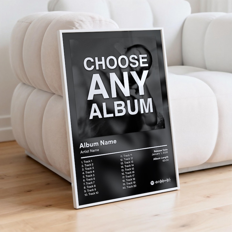 May include: A framed black and white album art print. The print features the words "CHOOSE ANY ALBUM" in bold white letters. Below, the print includes space for the album name, artist, track list, release date, and album length.
