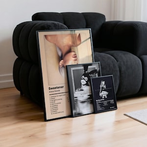 May include: Three framed posters featuring Ariana Grande album art. The "Sweetener" poster has a beige background with the album title and tracklist. The other two are black and white, with "Dangerous Woman" and "My Everything" album art.