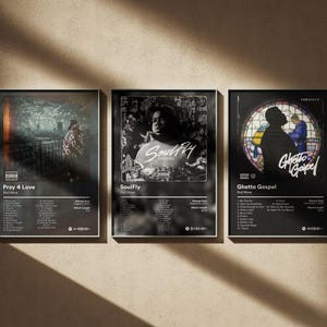 May include: Three framed album art prints. The first features a person on a bridge, the second a portrait, and the third a silhouette in a stained-glass window. Each print has a title, artist, and tracklist.