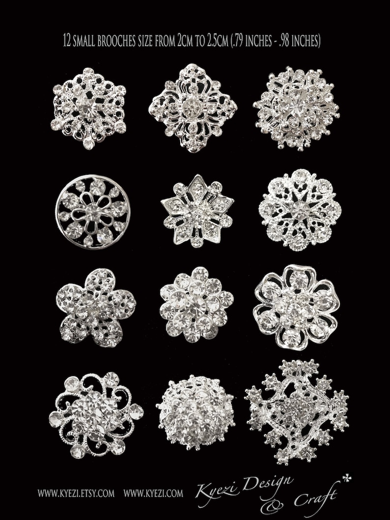 May include: Twelve silver brooches with crystal embellishments in various designs, including floral, geometric, and snowflake patterns. The brooches are approximately 2 to 2.5 cm in size.