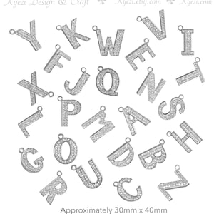 May include: Assortment of silver-toned metal letter charms, each letter is covered in small rhinestones. The letters are approximately 30mm x 40mm in size.